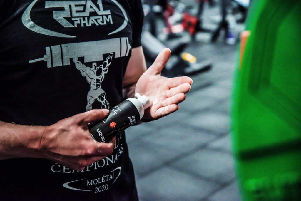 man pouring small amount of liquid chalk on its hands